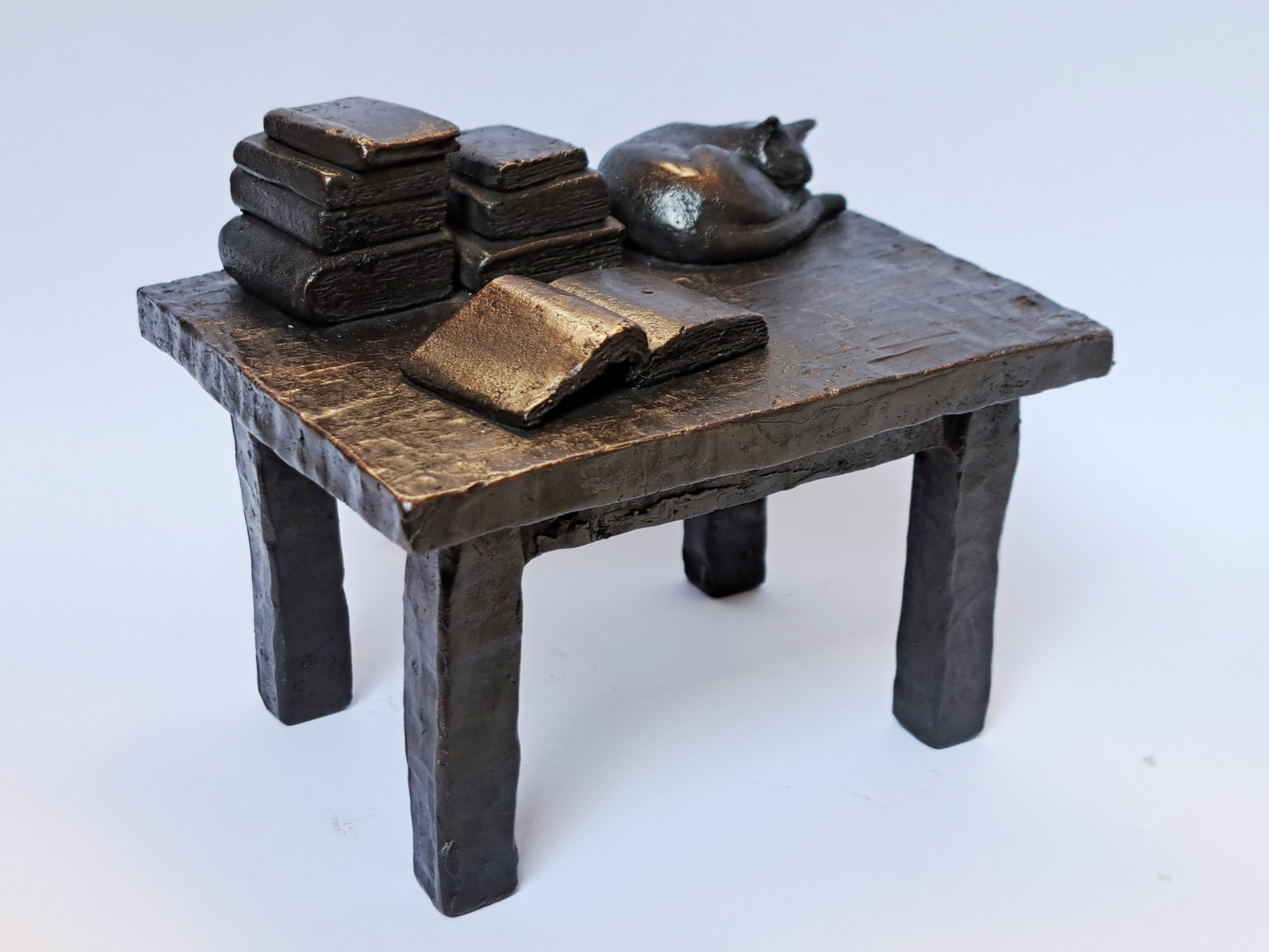Bronze table with books and a cat